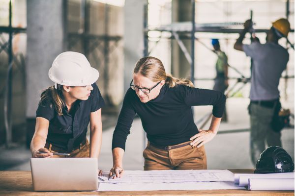 Two women collaborating on a construction project in Brooklyn, showcasing skills in building design and general contracting.