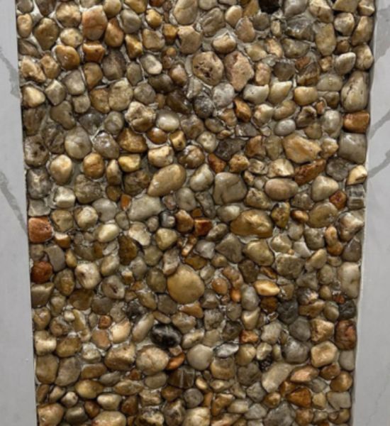 A textured stone wall adorned with pebbles and rocks, showcasing craftsmanship in construction and design.