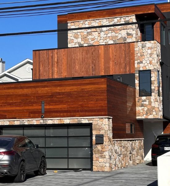 A contemporary home featuring a garage and two parked cars, showcasing modern architectural design and functionality.