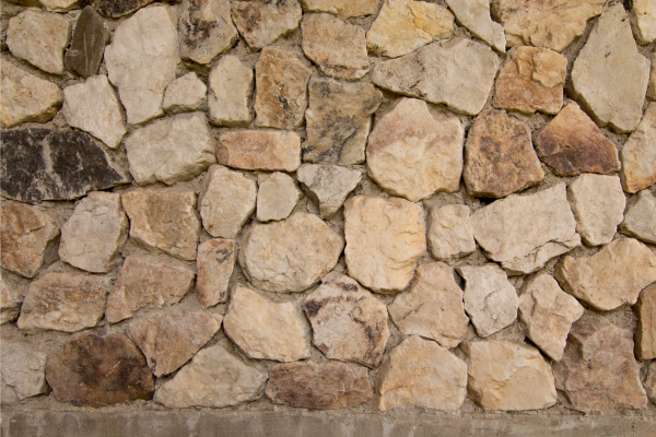 A sturdy wall constructed from various rocks, showcasing the craftsmanship of Greater Mansion in Brooklyn, NY.