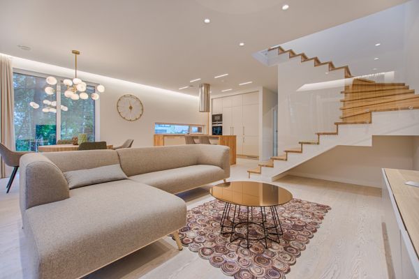 A modern living room design with a staircase and couch, highlighting contemporary style in Brooklyn, NY.