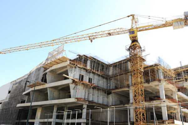 A construction crane stands tall in front of a building under construction in Brooklyn, NY, showcasing Greater Mansion's services.