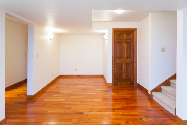 A hallway featuring a polished wooden floor and a door, showcasing the elegance of Greater Mansion in Brooklyn, NY.