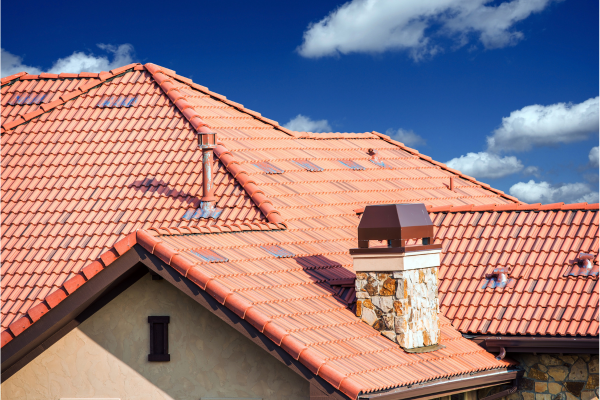 A red tile roof with a chimney, showcasing quality construction by Greater Mansion in Brooklyn, NY.