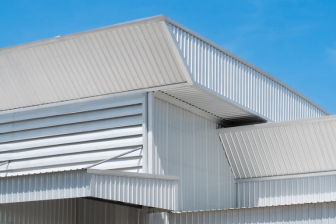 A white building with a metal roof, representing Greater Mansion's expertise in construction and design in Brooklyn.