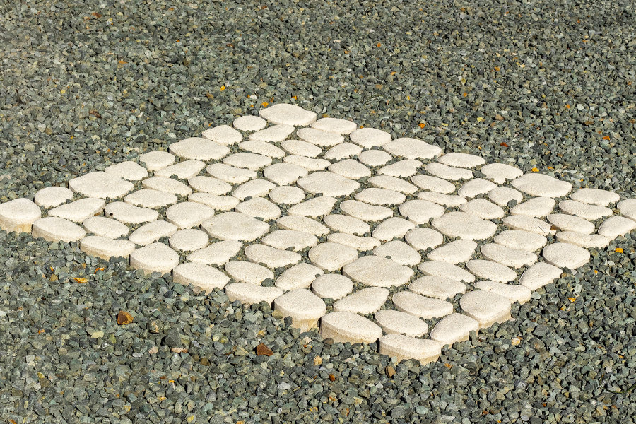 A neatly organized square of white pebbles on a gravel background, reflecting attention to detail in building design.