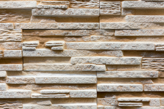 A multi-colored stone wall representing the diverse materials used in construction, crafted by Greater Mansion in Brooklyn.