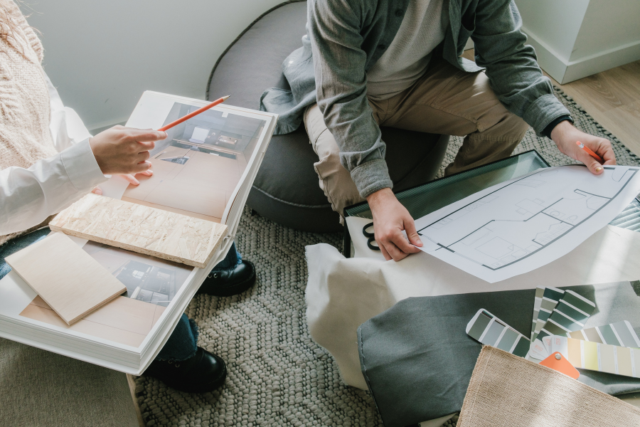 A man and woman seated on a couch, reviewing a document, symbolizing collaboration in construction and design projects.