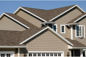 A house with a gray roof and white trim, exemplifying the craftsmanship of Greater Mansion, a general contractor in Brooklyn, NY.