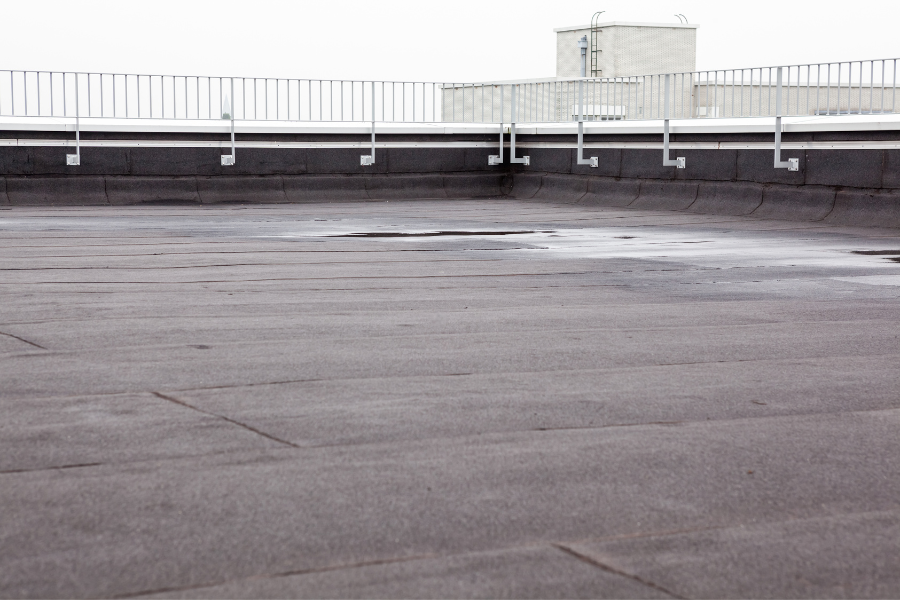 A man stands on a Brooklyn roof with a skateboard, showcasing urban lifestyle and construction creativity.