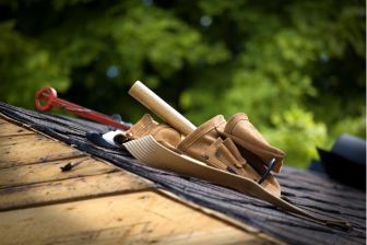 A roofing tool and hammer positioned on a rooftop, symbolizing construction and remodeling services by Greater Mansion in Brooklyn.